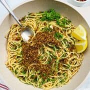 Pasta dish: Anchovy pasta -spaghetti- in a pan with chopped parsley, garlic breadcrumbs and lemon.