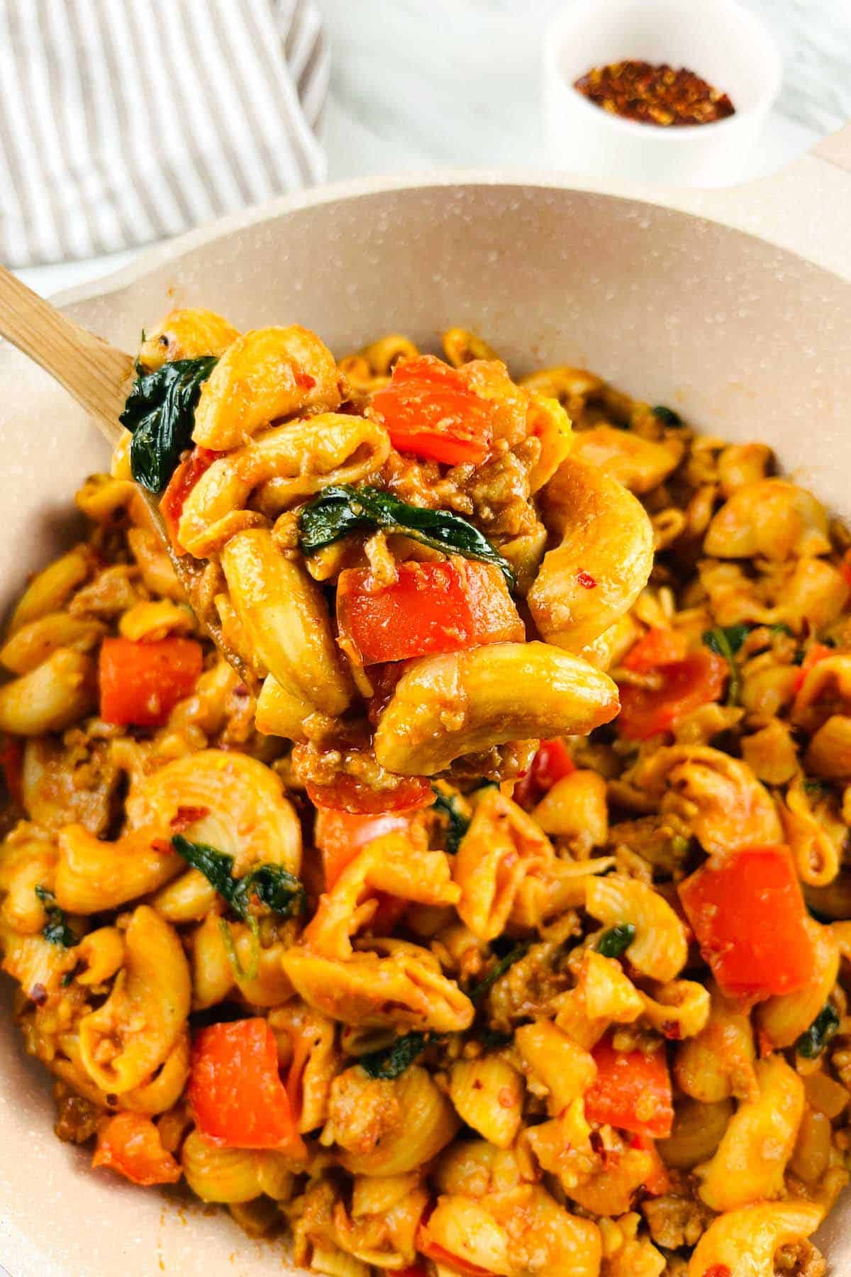 Pasta Dish : Pasta in a pot with ground beef, red bell pepper and spinach.